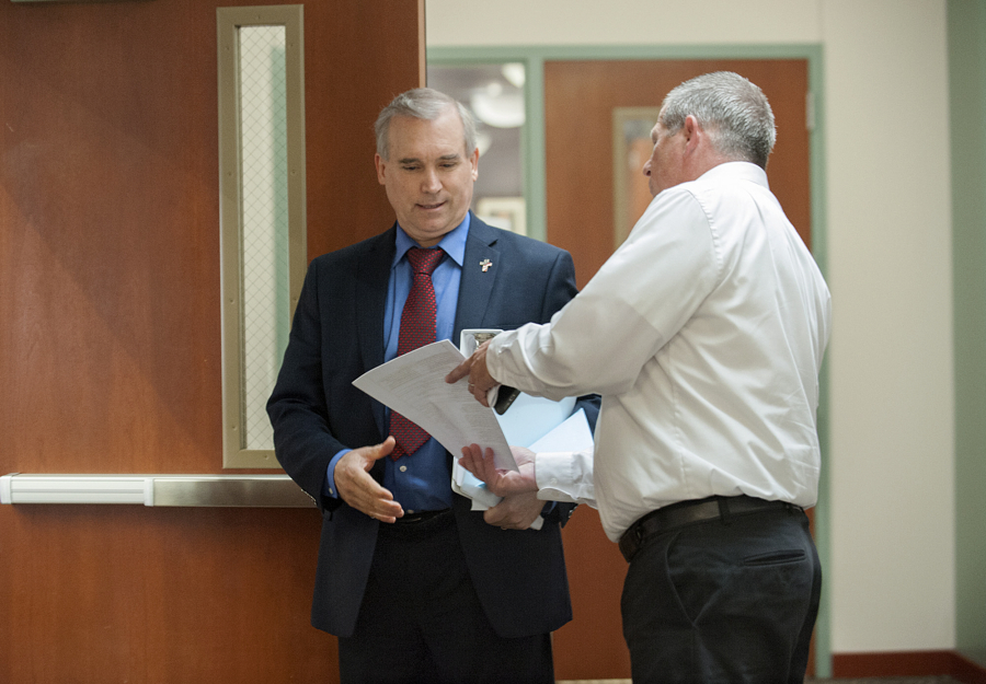 Clark County Councilor David Madore, left, is served with a summons by process server Brian Davis Tuesday morning at the Clark County Public Service Center.