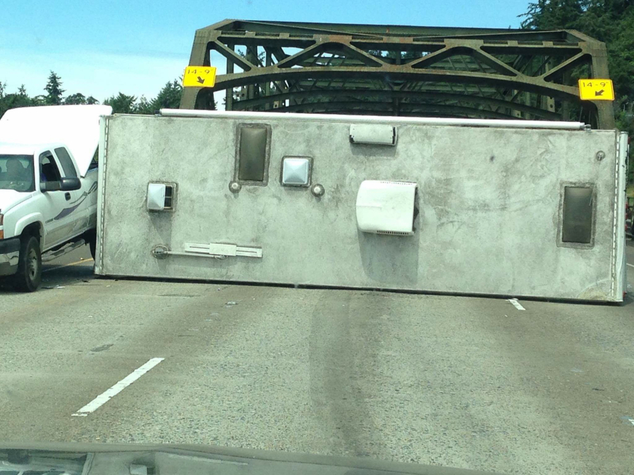 A rolled travel trailer blocks all three lanes of northbound traffic Friday on Interstate 5 near Woodland.