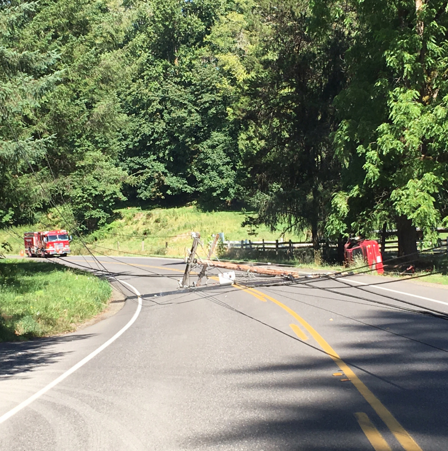 Tangled, fallen power lines block Northeast Hayes Road east of Woodland after a car, at right, crashed into a power pole and knocked it over. The driver was able to climb from the car after the crash, Clark County Fire &amp; Rescue Battalion Chief Tim Dawdy said.