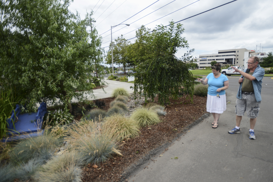 Rene Jordan, owner of Peach Willow Spa in Vancouver, talks with passerby Randall Hollaus about her garden being featured in the &quot;Pokemon Go&quot; game Friday.