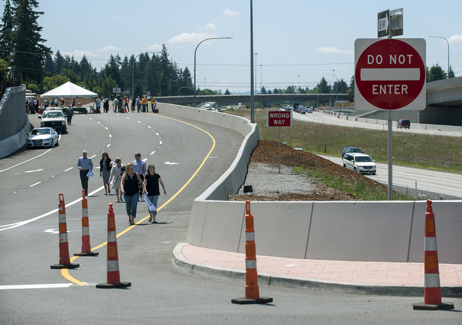 Participants in the Wednesday morning ribbon-cutting event walk down the new I-205 northbound offramp to Northeast 18th Street following the ceremony, and before the road opened to traffic for the afternoon commute.