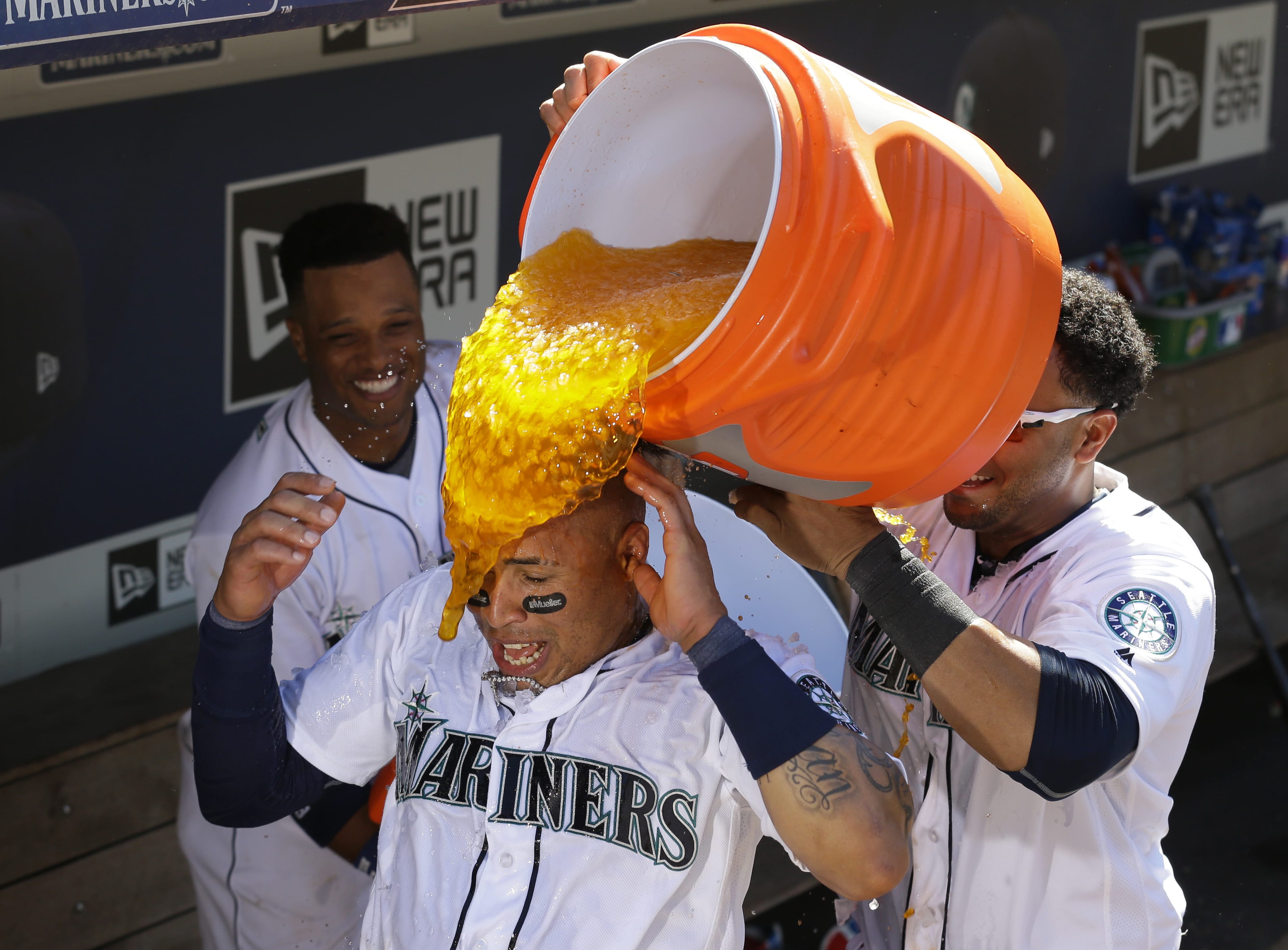 Seattle Mariners' Leonys Martin, center, is doused with water and sports drink by teammates Robinson Cano, left, and Nelson Cruz, right, after Martin hit a solo walk-off home run in the 11th inning of a baseball game to give the Mariners a 6-5 win over the Chicago White Sox, Wednesday, July 20, 2016, in Seattle. (AP Photo/Ted S.