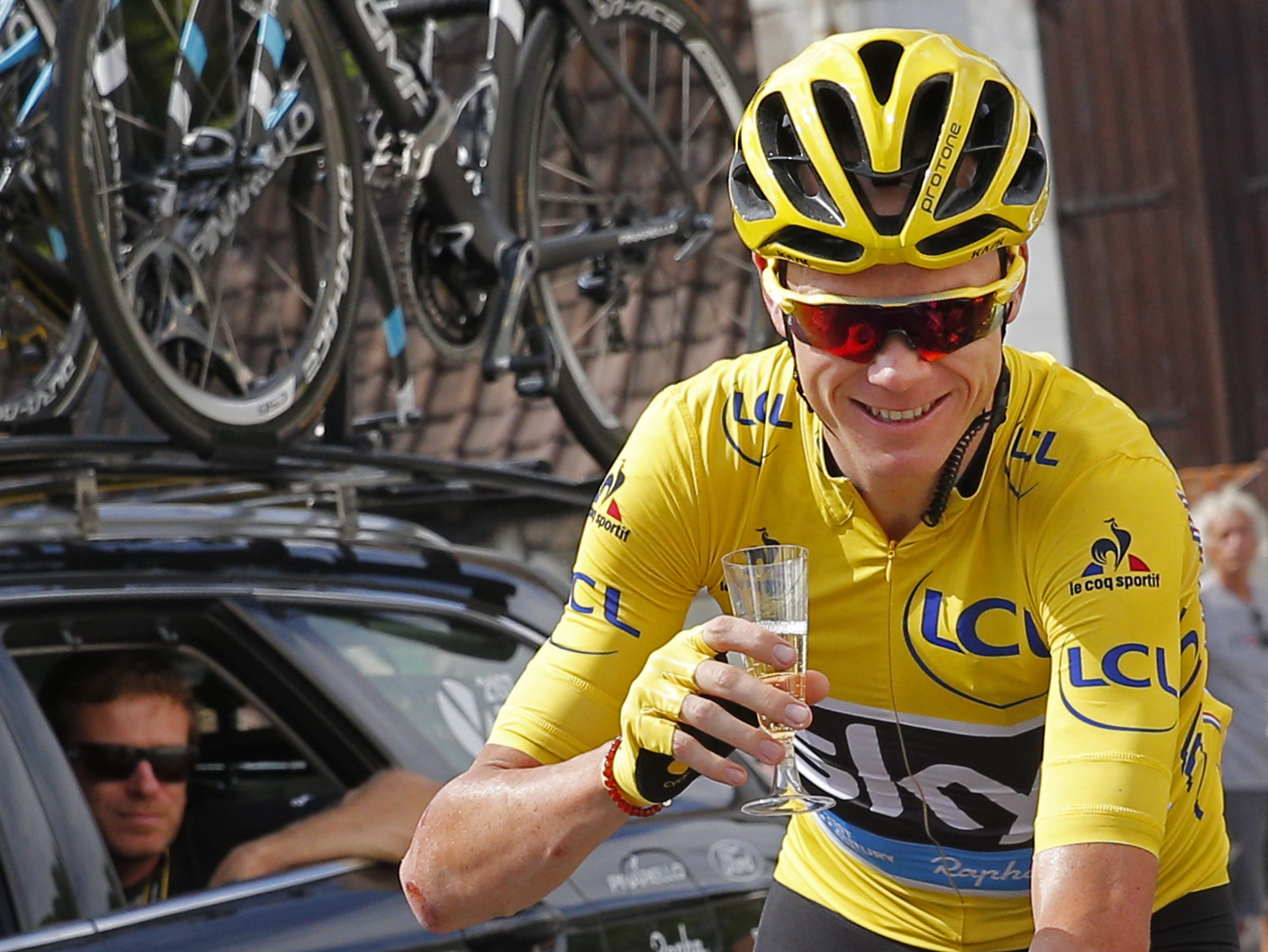Britain's Chris Froome, wearing the overall leader's yellow jersey, celebrates with a glass of champagne during the twenty-first stage of the Tour de France cycling race over 113 kilometers (70.2 miles) with start in Chantilly and finish in Paris, France, Sunday, July 24, 2016.