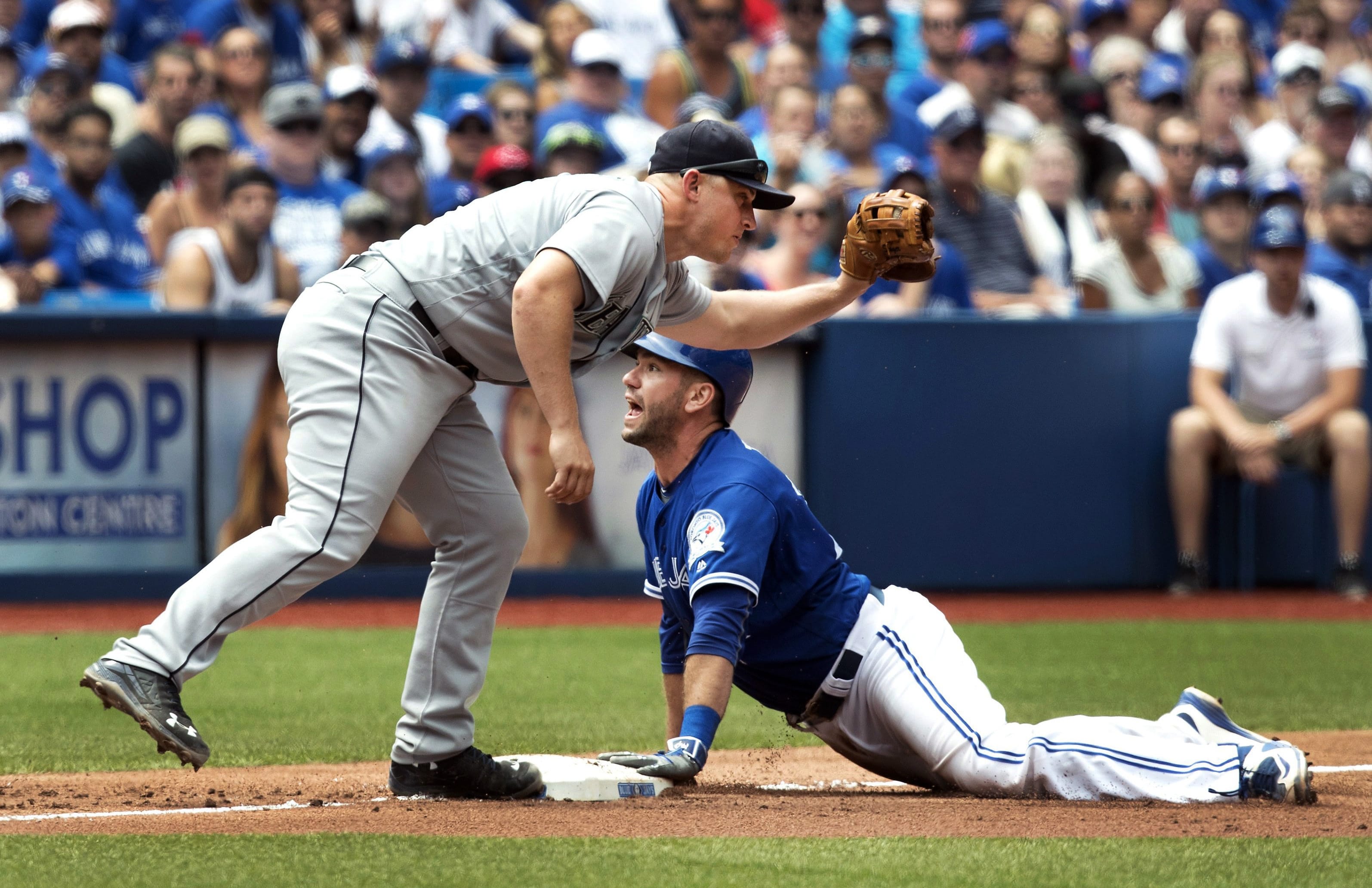 Toronto Blue Jays' Josh Thole, right, is safe at third base as Seattle Mariners Kyle Seager is late with the tag during the sixth inning of a baseball game in Toronto, Sunday, July 24, 2016.