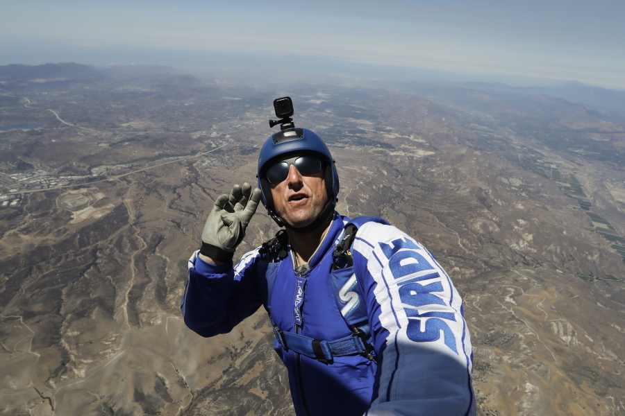 Skydiver Luke Aikins signals to pilot Aaron Fitzgerald as he prepares to jump from a helicopter Monday in Simi Valley, Calif. (Jae C.