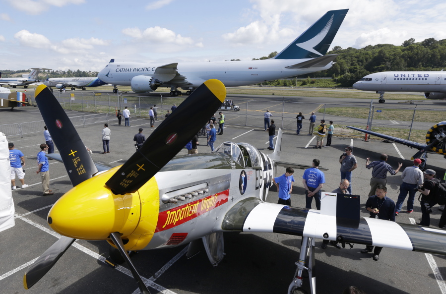 Airplanes, including a P-51B Mustang, left, and a Cathay Pacific 747 Cargo plane, top, sit parked on display Friday during the event in Seattle.