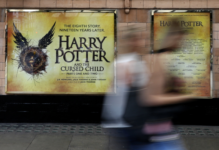 Pedestrians pass a poster advertising the new Harry Potter play, at the Palace Theatre in London. Nine years after J.K. Rowling&#039;s final novel about the boy wizard, Harry has returned, on the stage and the page. &quot;Harry Potter and the Cursed Child&quot; is being released tonight.