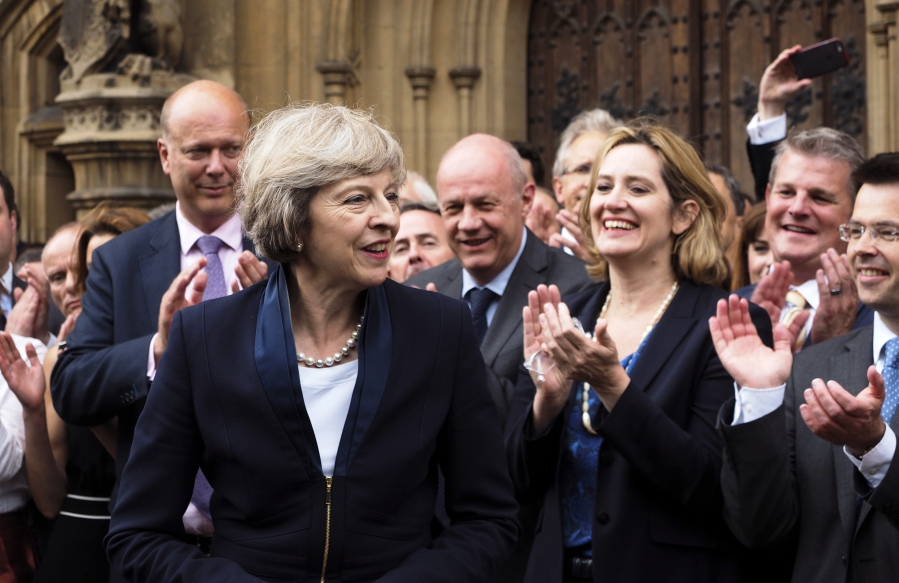 Theresa May, left, is applauded by Conservative Party members Monday outside the Houses of Parliament in London. Prime Minister David Cameron has said he will step down on Wednesday and May will replace him.