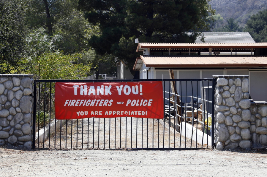 A banner thanking first responders hangs Tuesday, July 26, 2016, in front of a home that escaped damage after the Sand fire swept through Santa Clarita, Calif. over the weekend. The fire destroyed 18 homes and authorities said that by Tuesday it had burned more than 37,000 acres, about 58 square miles. (AP Photo/Nick Ut) (RINGO H.W.