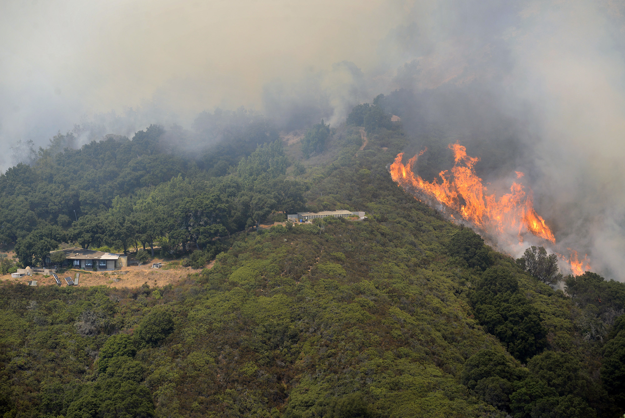 A wildfire burns in the Palo Colorado Canyon in the scenic Big Sur region of California's Central Coast, Monday, July 25, 2016. Fire crews have made some gains against a massive wildfire burning in rugged terrain near the scenic Big Sur region.