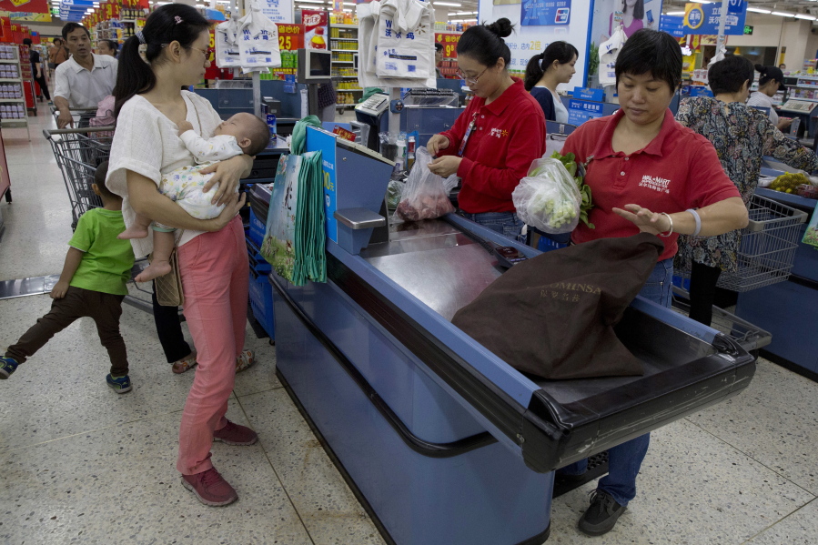 Workers tend to customers paying for purchases at a Wal-Mart in Shenzhen, in southern China&#039;s Guangdong province.