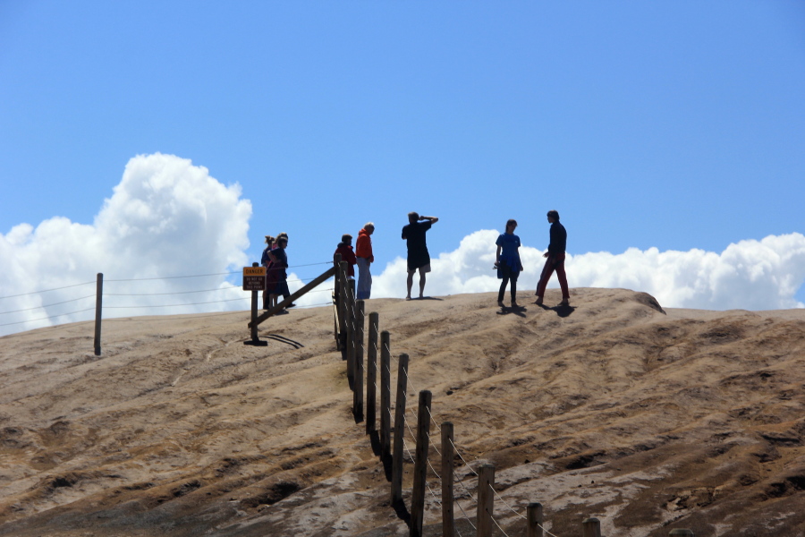 Visitors walk past the fence guarding the bluffs at Cape Kiwanda State Natural Area in Cloverdale, Ore. Everyone from photographers to families ignore warnings in order to get the perfect photo at the Oregon Coast's deadliest cape, where six people have died in the last 18 months.
