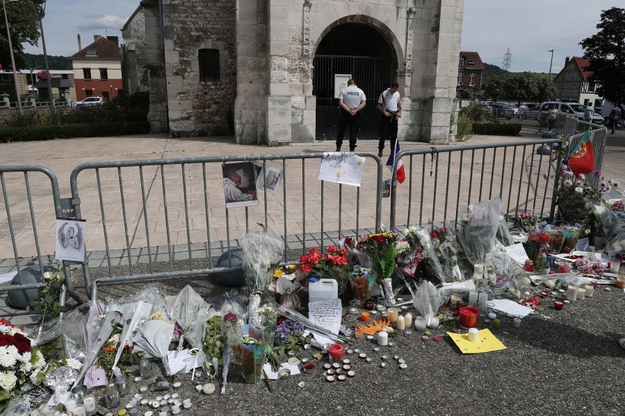 Flowers and candles are displayed at a makeshift memorial in front of the Saint Etienne church where Priest Jacques Hamel was killed on 26 July in a hostage taking in Saint-Etienne-du-Rouvray, Normandy, France, Thursday, July 28, 2016. The second man who attacked a Normandy church during a morning Mass this week, slitting the throat of the elderly priest, is a 19-year-old Frenchman from eastern France, the prosecutor&#039;s office said Thursday.