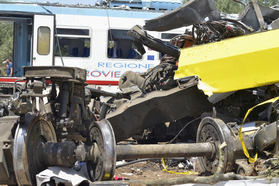 The wreckage of a carriage lies on a field near the railroad as recovery operations continued a day after two commuter trains slammed into one another just before noon Tuesday in Puglia, between the towns of Corato and Andria, Italy, on Wednesday. Delayed rail improvements and the antiquated telephone alert system will be considered as part of the investigation into the violent head-on train crash in southern Italy that killed nearly two dozen people, officials said Wednesday.