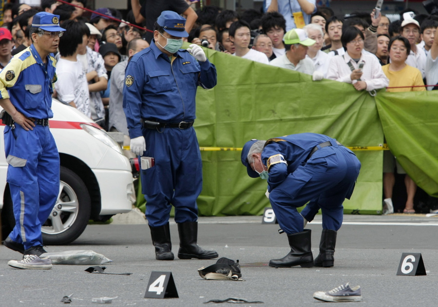 Police investigators examine the crime scene of Tokyo&#039;s Akihabara electronics district after a man slammed a truck into a crowd of shoppers, jumped out and went on a stabbing spree, killing  seven people.