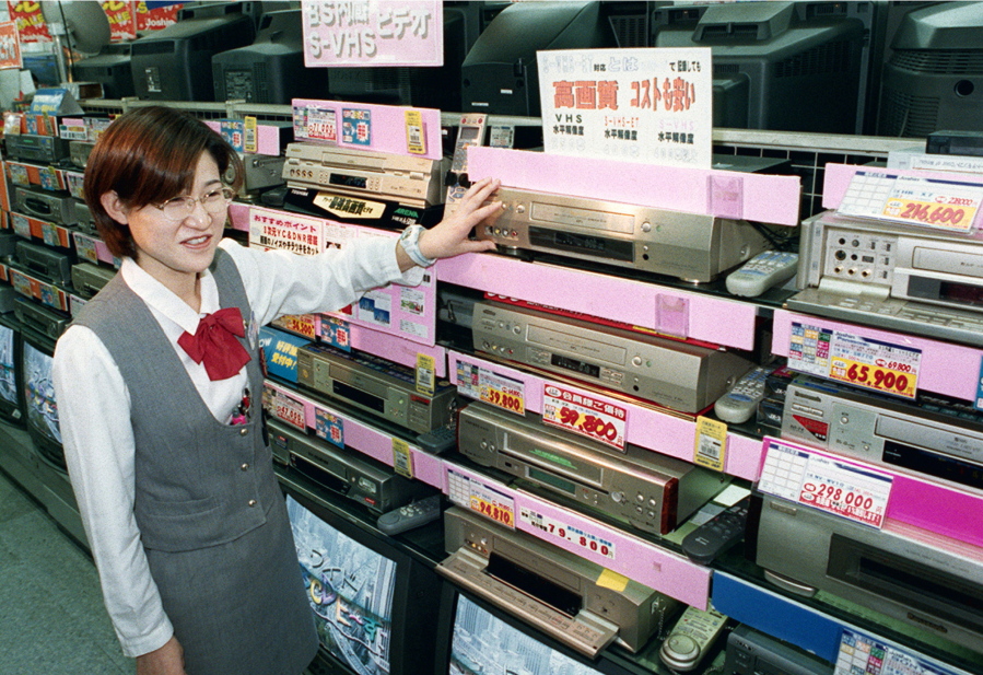 A salesclerk shows high-quality VHS video casette recorders Oct. 31, 1998 at a home and electrical appliance store in Osaka, Japan. Japanese electronics maker Funai Electric Co. says it&#039;s yanking the plug on the world&#039;s last video cassette recorder.