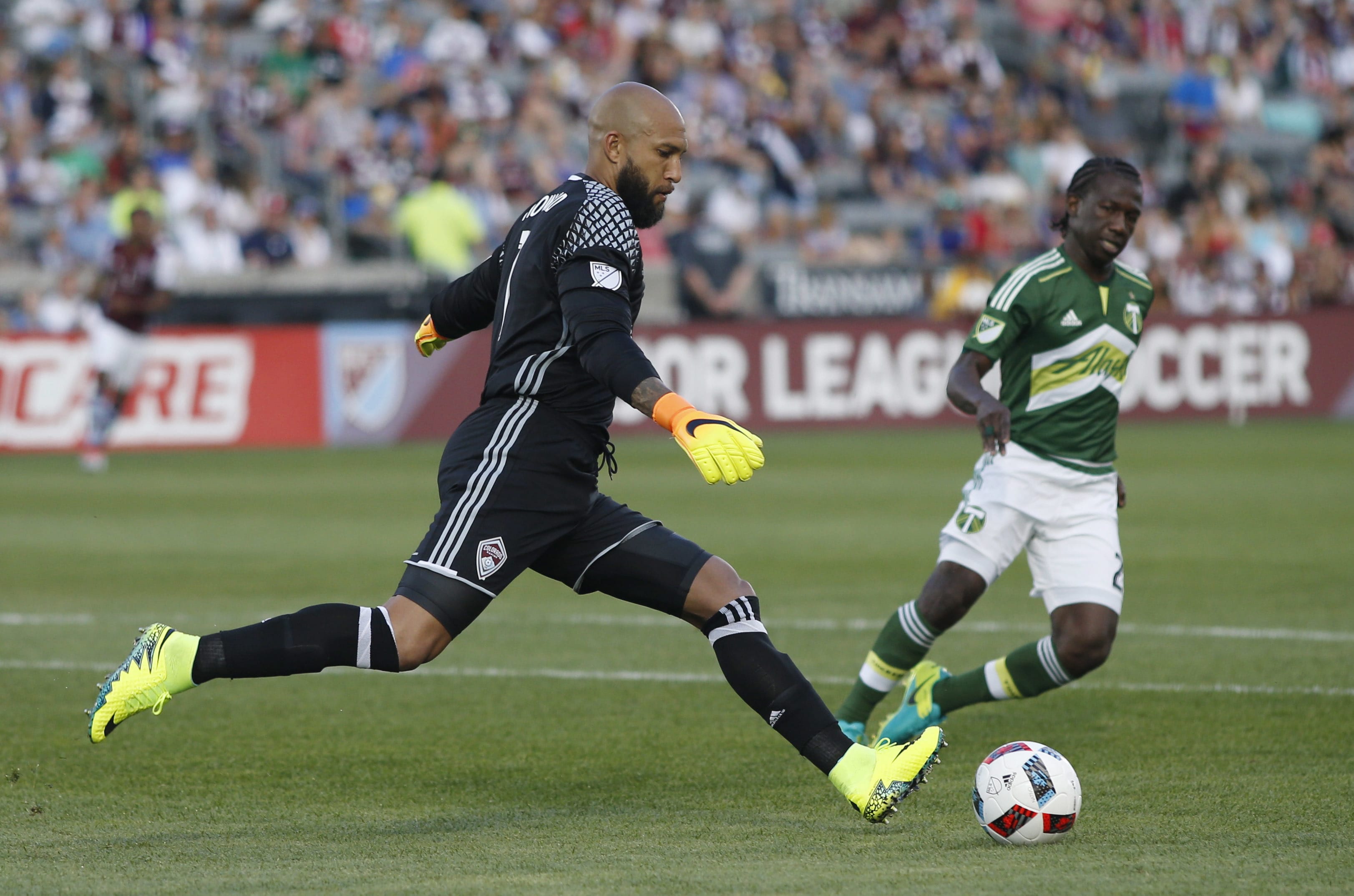 Colorado Rapids goalkeeper Tim Howard, front, clears the ball as Portland Timbers forward Diego Chara defends in the first half of an MLS soccer match Monday, July 4, 2016, in Commerce City, Colo.