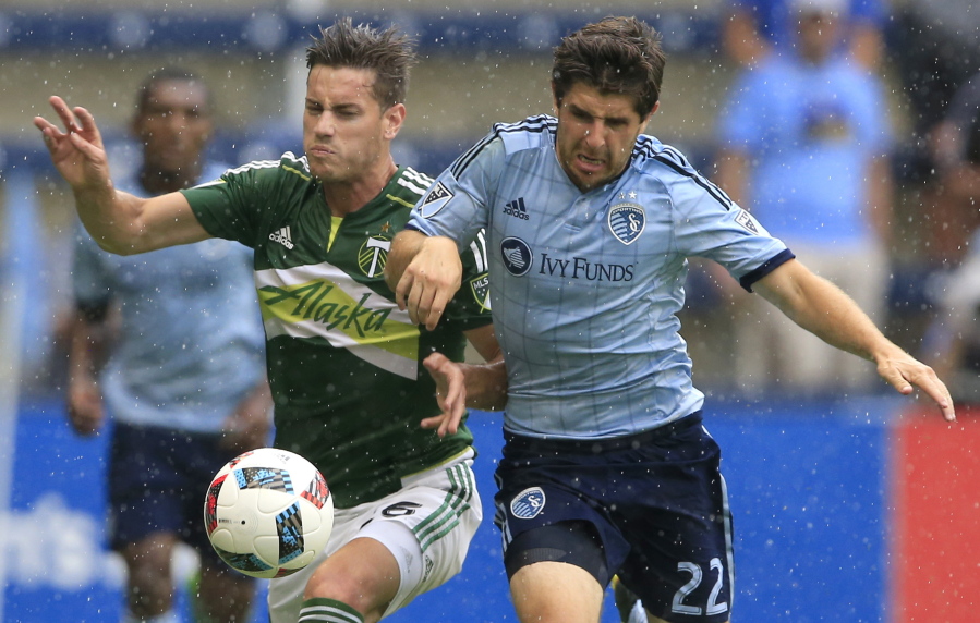 Portland Timbers forward Lucas Melano (26) and Sporting Kansas City midfielder Connor Hallisey (22) race for the ball during the first half of an MLS soccer match in Kansas City, Kan., Sunday, July 31, 2016.