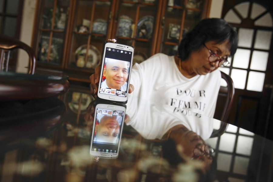 Sakinab Shah, sister of Capt. Zaharie Ahmad Shah, the senior pilot on Malaysian Flight 370, holds up her phone with a picture of her brother during an interview in February in Kuala Lumpur, Malaysia.