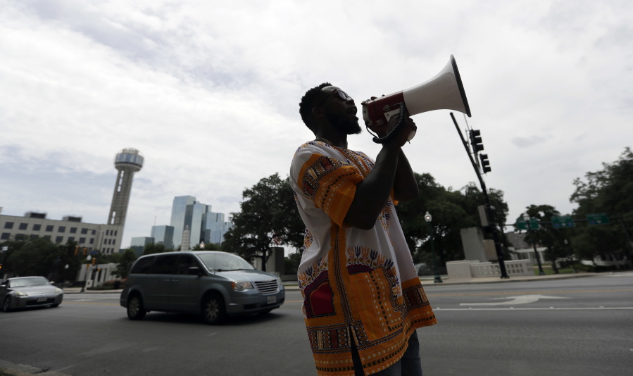 Gregory Bernard Smith, who supports Black Lives Matter, stands near Dealey Plaza as he denounces the killing of five police officers, Saturday, July 9, 2016, in Dallas. After five police officers were killed in a shooting Thursday, a city forever haunted by the assassination of John F. Kennedy is trying to not let the worst America attack on police since Sept. 11 define it again.