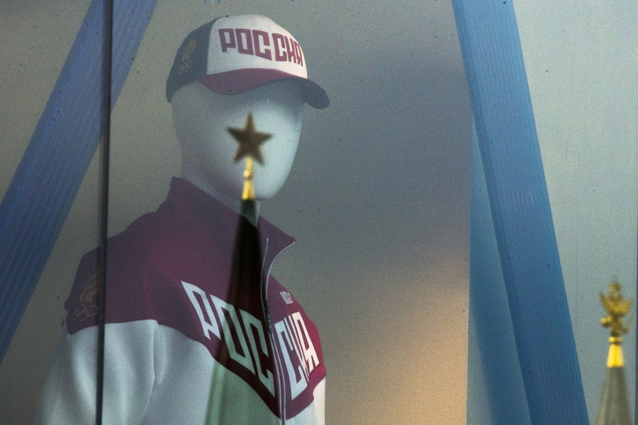A mannequin dressed in a Russian Olympics National team uniform is on display in a shop window, with the Kremlin tower star reflected on a window glass, in Moscow, Russia, on Tuesday. The Executive Board of the International Olympic Committee meets Tuesday by teleconference to rule on what action to take against Russia for the mass doping program confirmed by the world anti-doping agency on Monday.