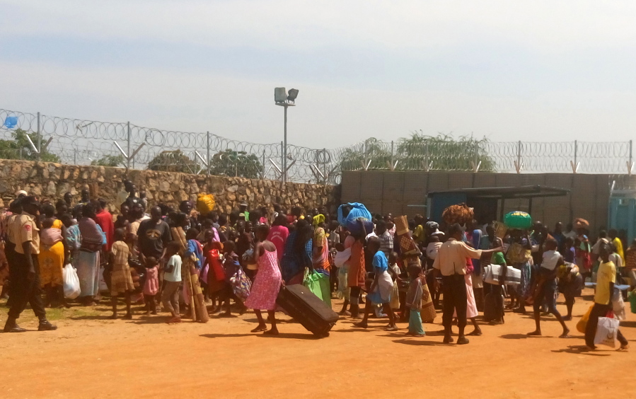 People with their luggage gather outside the gate seeking shelter in the World Food Program compound in Juba, South Sudan. Heavy explosions were shaking South Sudan&#039;s capital, Juba, on Monday morning as clashes between government and opposition forces entered their fifth day, witnesses said, pushing the country back toward civil war.