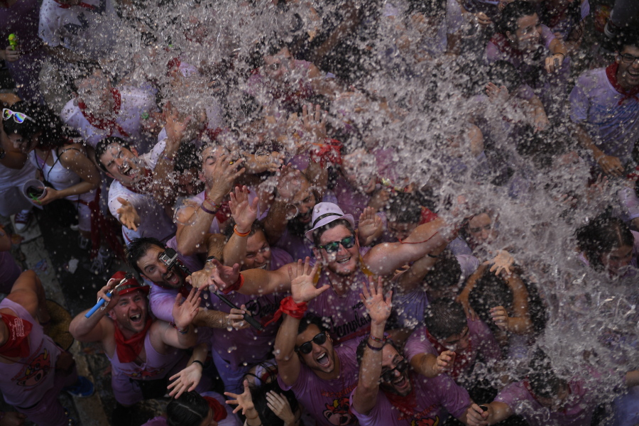 People are refreshed with water thrown from a balcony during the launch of the &quot;Chupinazo&quot; fireworks rocket to celebrate the official opening of the 2016 San Fermin Fiestas on Wednesday in Pamplona, Spain.