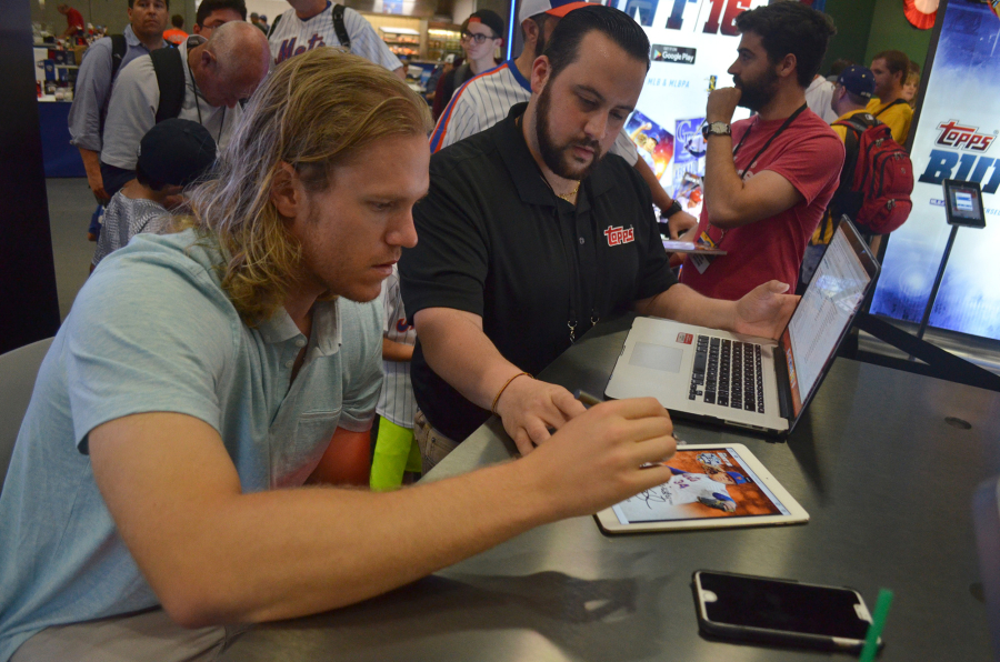 New York Mets pitcher Noah Syndgeraard and Chris R. Vaccaro, director of app production for The Topps Co., take part in a promotion of Topps&#039; MLB Bunt app during a live digital signing at MLB All-Star FanFest in San Diego.