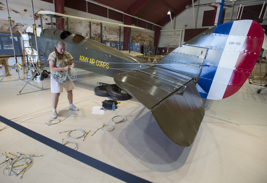 Karen Barrow of Century Aviation assembles Pearson Air Museum&#039;s biplane -- right side up -- Wednesday.