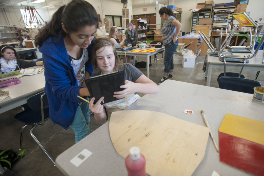 Savanna Falkner, a student at Vancouver School of Arts and Academics, uses an iPad to show a classmate in May 2015 how she will paint the coat of arms of a 13th-century English nobleman who was part of the Magna Carta effort.