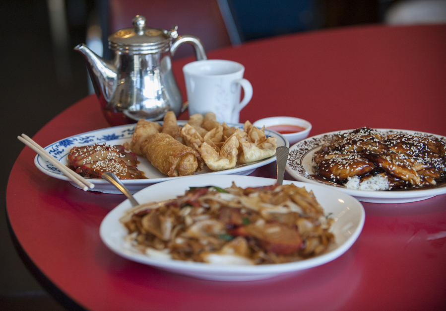 The special plate appetizer, clockwise from back left, is served Aug. 19 with the teriyaki chicken rice bowl and chow fun with roast pork at Tang&#039;s Wok in Vancouver. The items in the appetizer are barbecue pork, shrimp, an egg roll and crab puffs.