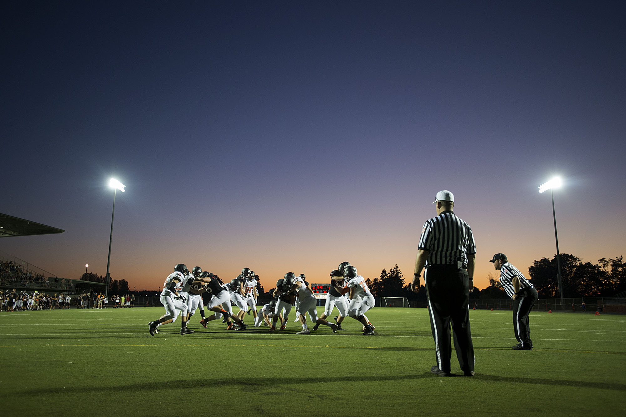 Members of the Battle Ground varsity team face off during a scrimmage as stadium lights illuminate the field Thursday evening, Aug. 25, 2016 at Battle Ground High School.