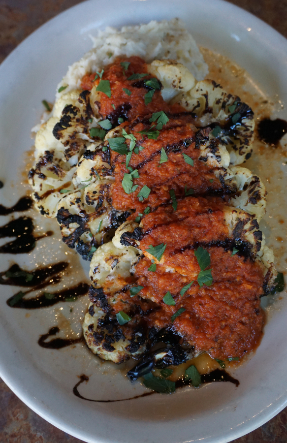 The smoky, earthy flavor of this cauliflower &quot;steak&quot; -- a new offering at Mill Creek Pub, comes from oven roasting, grilling and serving with a fresh marinara sauce and balsamic reduction.