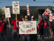 Teacher librarians Kristie Peak of Mill Plain Elementary School, foreground, and Beth Pfenning of Hearthwood Elementary School join picketers Friday morning, Aug. 19, 2016 in Southeast Vancouver.