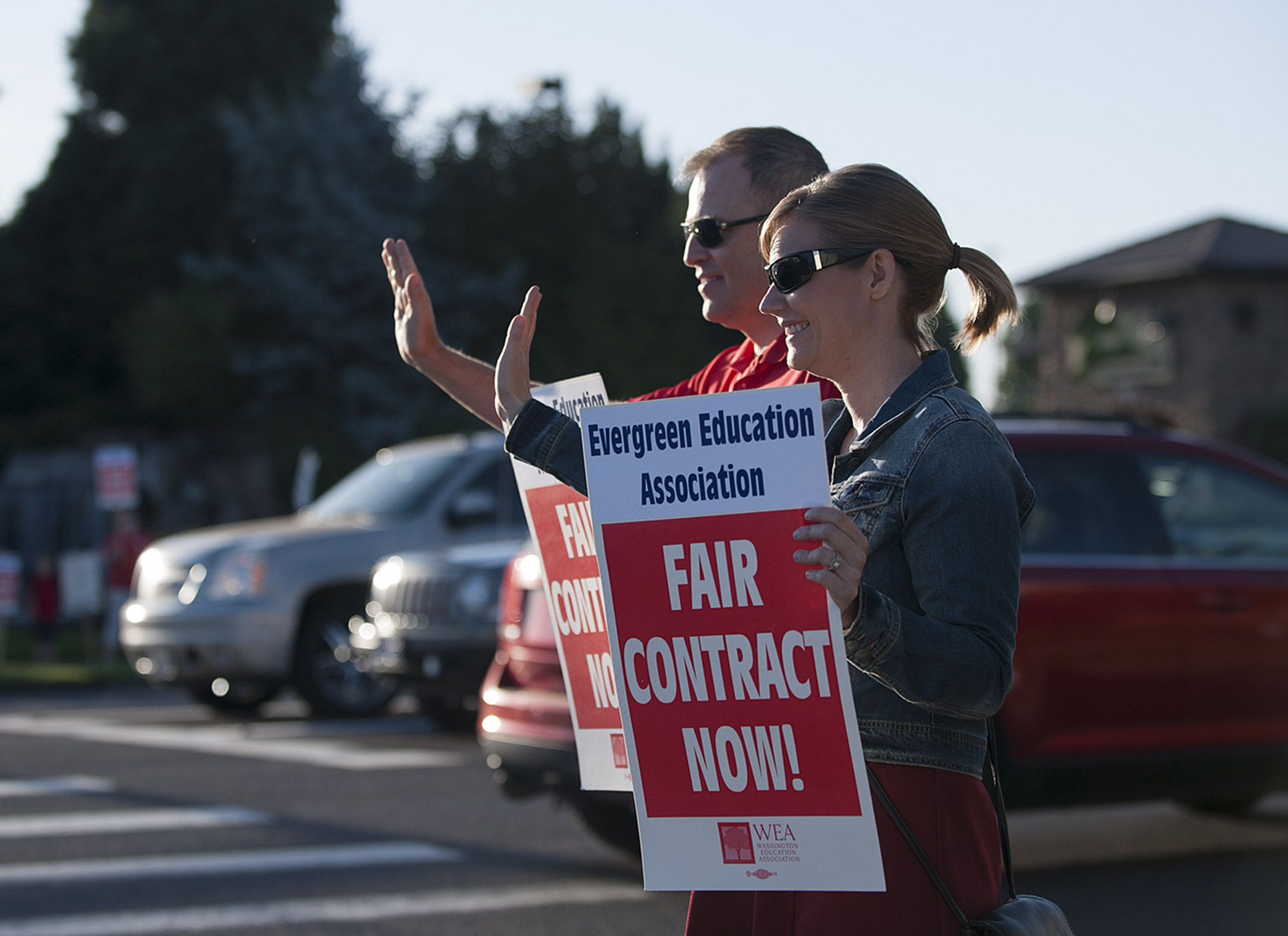 Cascade Middle School teacher Matt Mandrones, left, and his wife, Shawn Mandrones, a teacher at Hockinson Heights Elementary School, wave to drivers Friday morning, Aug. 19, 2016 in Southeast Vancouver.