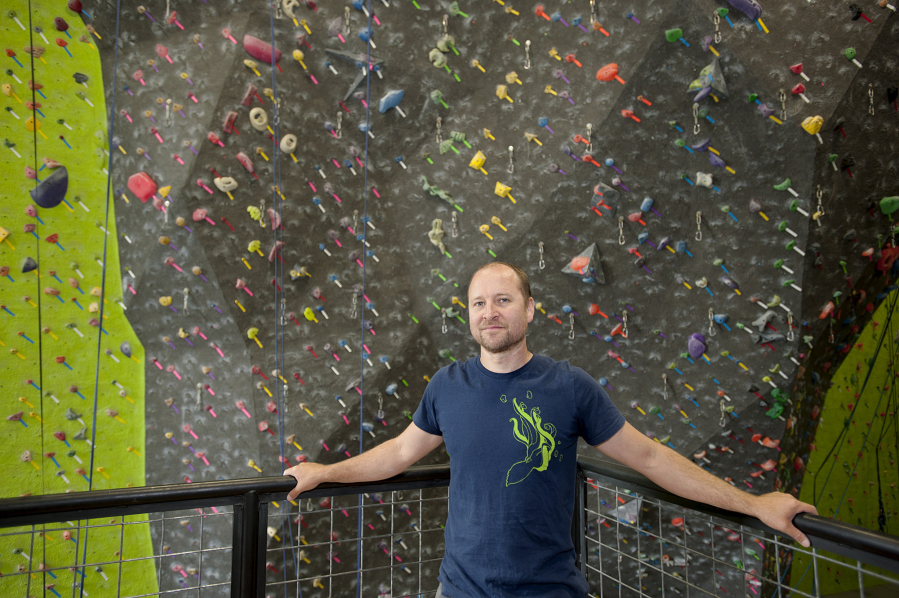 Hanz Kroesen, co-owner of Source Climbing Center, prepares routes for climbers.