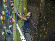 Hanz Kroesen, co-owner of Source Climbing Center, works on attaching holds.
