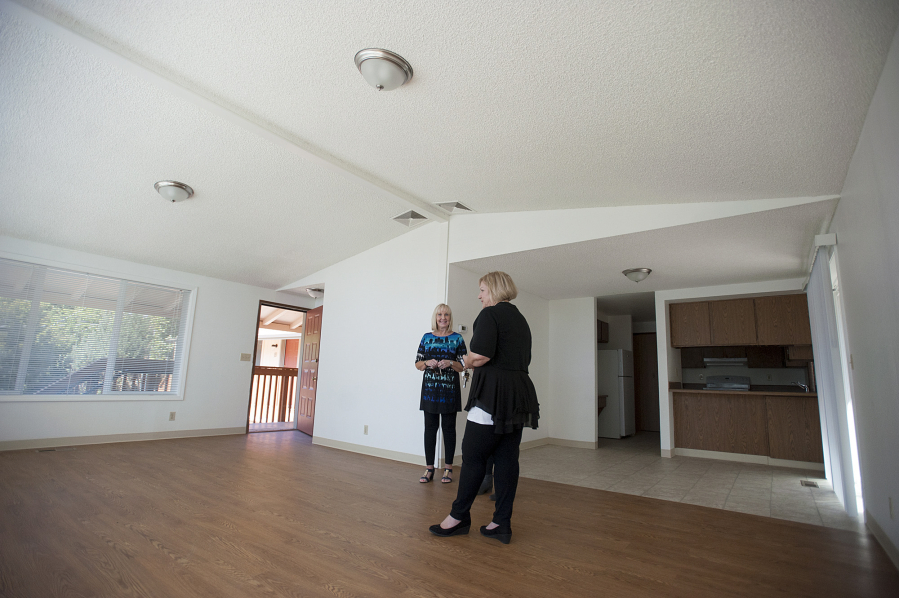 Debby Dover, executive director of Second Step Housing, left, looks over the living area of the largest unit at Horizon Place with Denise Stone, director of programs and asset management.