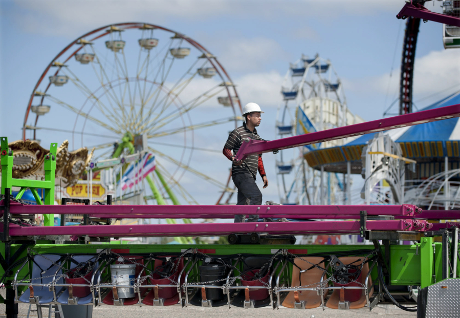 Gabriel Aguilar of Butler Amusements on Wednesday helps assemble the ride Vertigo as preparations continued for the Clark County Fair. The fair opens its 10-day run Friday. More information is at www.clarkcofair.com.