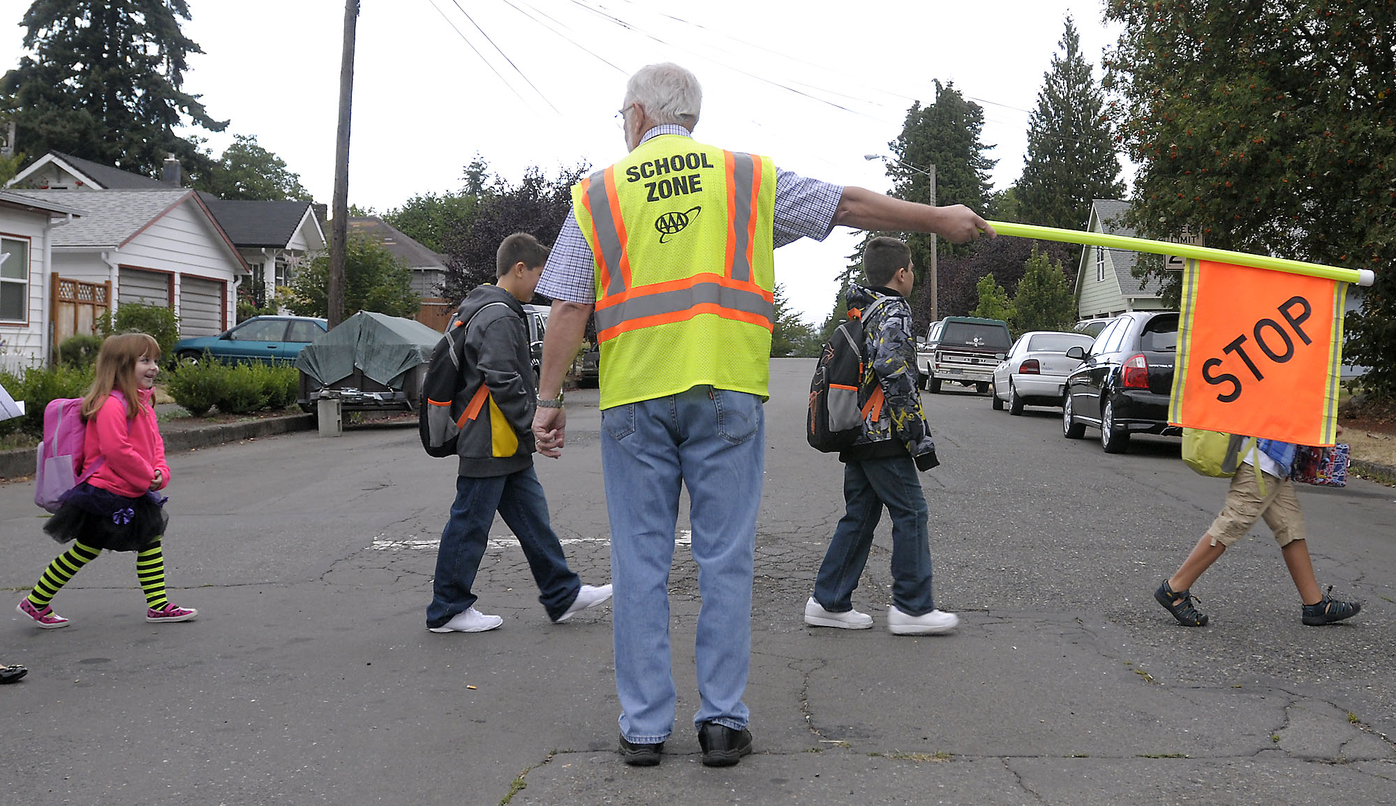Children walk on their way to the first day of classes at Washington Elementary School in 2014 with help from Mick Hawthorn and other walking school bus volunteers.
