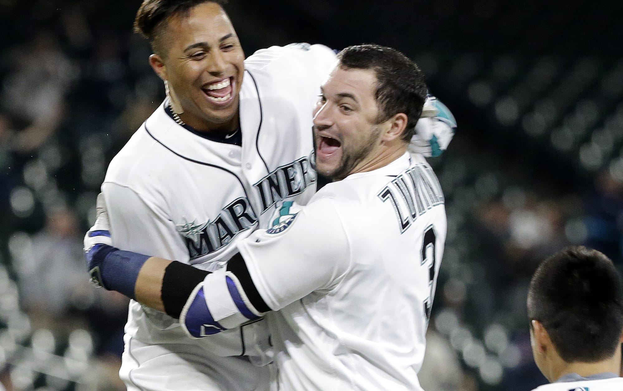 Seattle Mariners' Mike Zunino, right, is embraced by Leonys Martin after Zunino's sacrifice fly that gave the team a victory over the Detroit Tigers in the 15th inning of a baseball game Wednesday, Aug. 10, 2016, in Seattle. The Mariners won 6-5.