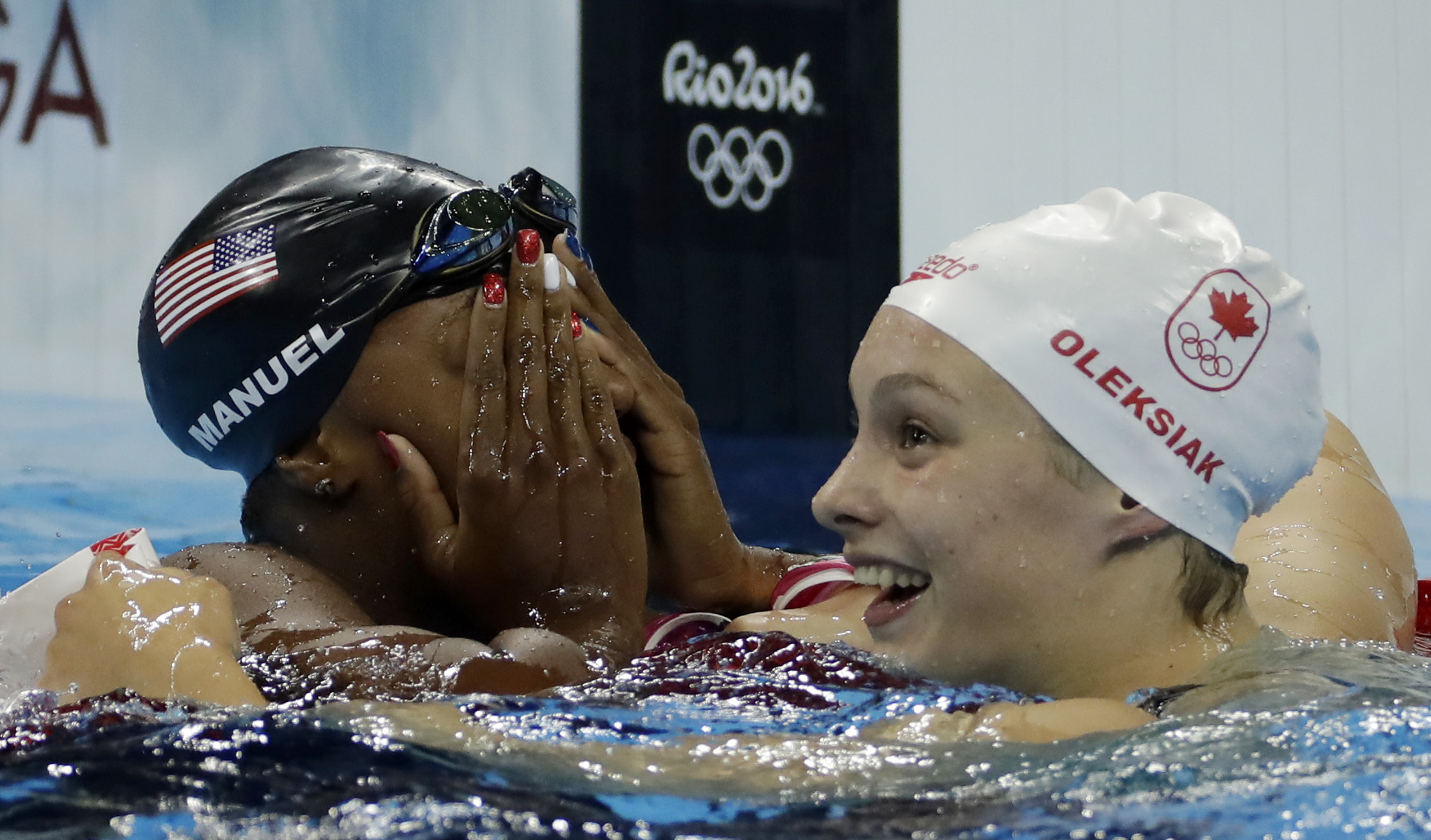 United States' Simone Manuel, left, and Canada's Penny Oleksiak celebrate winning joint gold and setting a new Olympic record in the women's 100-meter freestyle during the swimming competitions at the 2016 Summer Olympics, Thursday, Aug. 11, 2016, in Rio de Janeiro, Brazil.