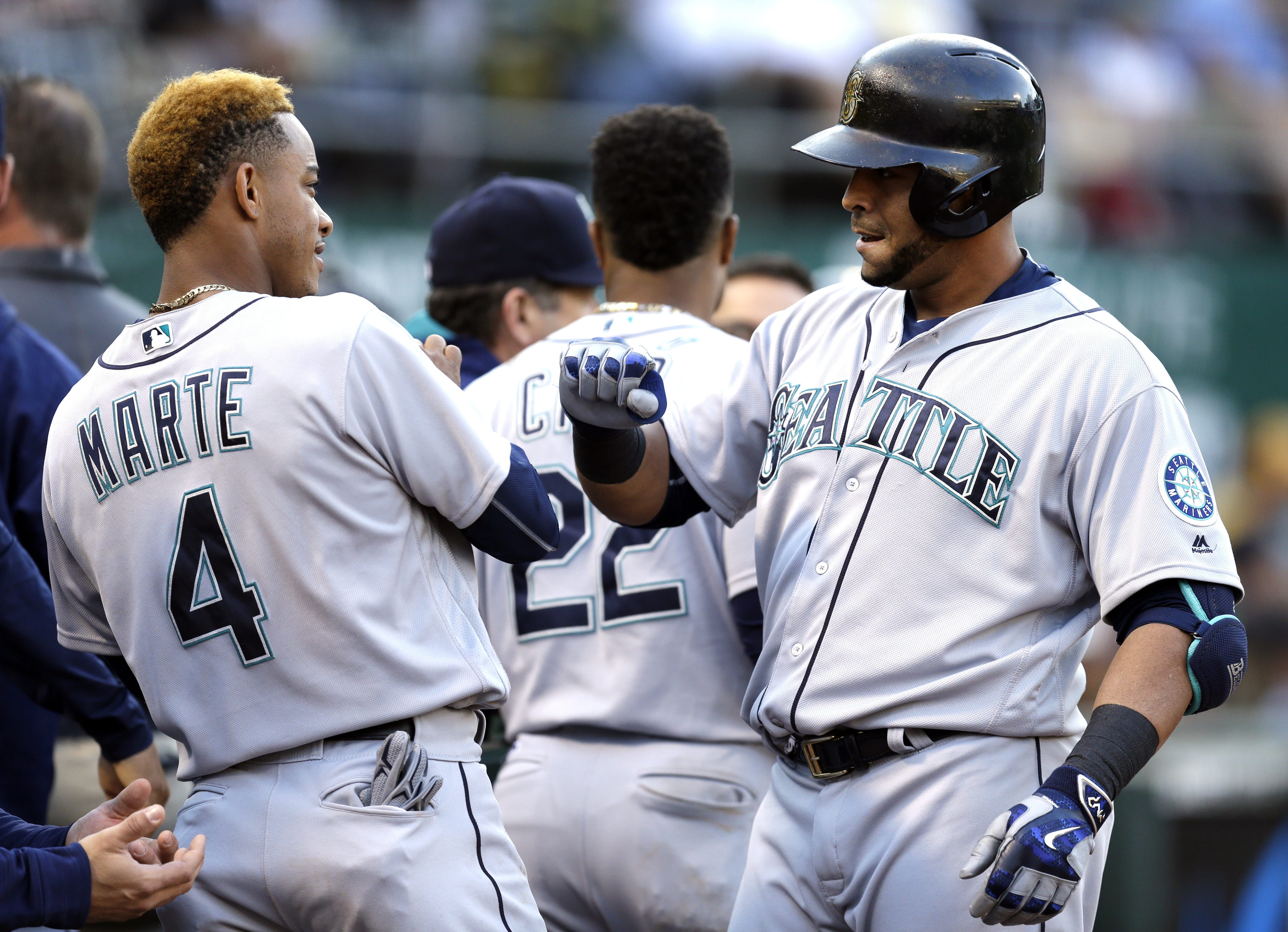 Seattle Mariners' Nelson Cruz, right, celebrates with Ketel Marte (4) after hitting a home run off Oakland Athletics pitcher Kendall Graveman in the fourth inning of a baseball game Saturday, Aug. 13, 2016, in Oakland, Calif.