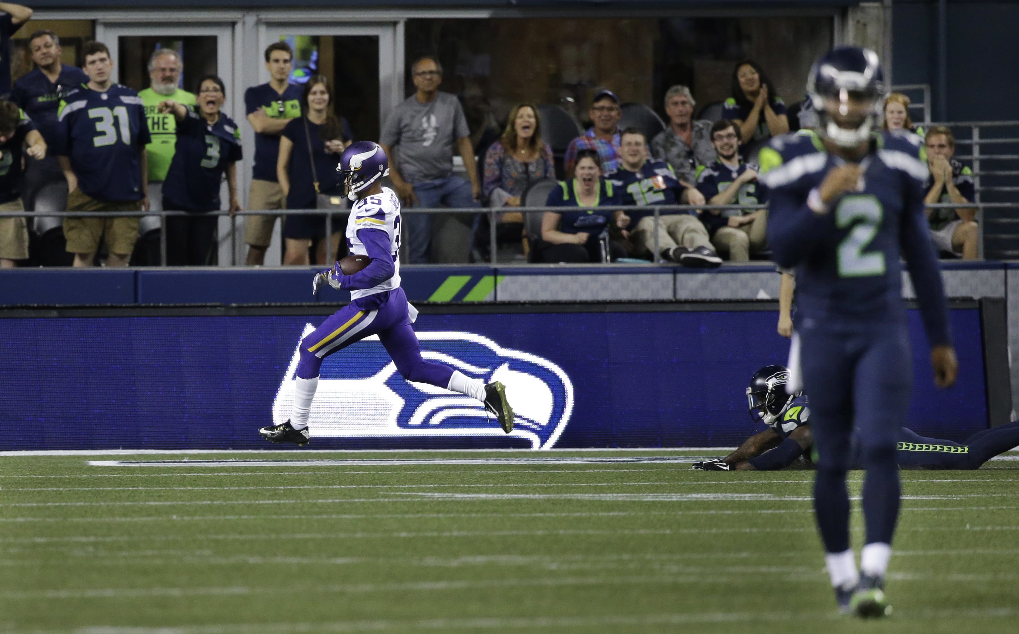Minnesota Vikings cornerback Marcus Sherels, left, scores the go-ahead touchdown after he intercepted a pass from Seattle Seahawks quarterback Trevone Boykin, right, during the second half of a preseason NFL football game, Thursday, Aug. 18, 2016, in Seattle. The Vikings won 18-11.