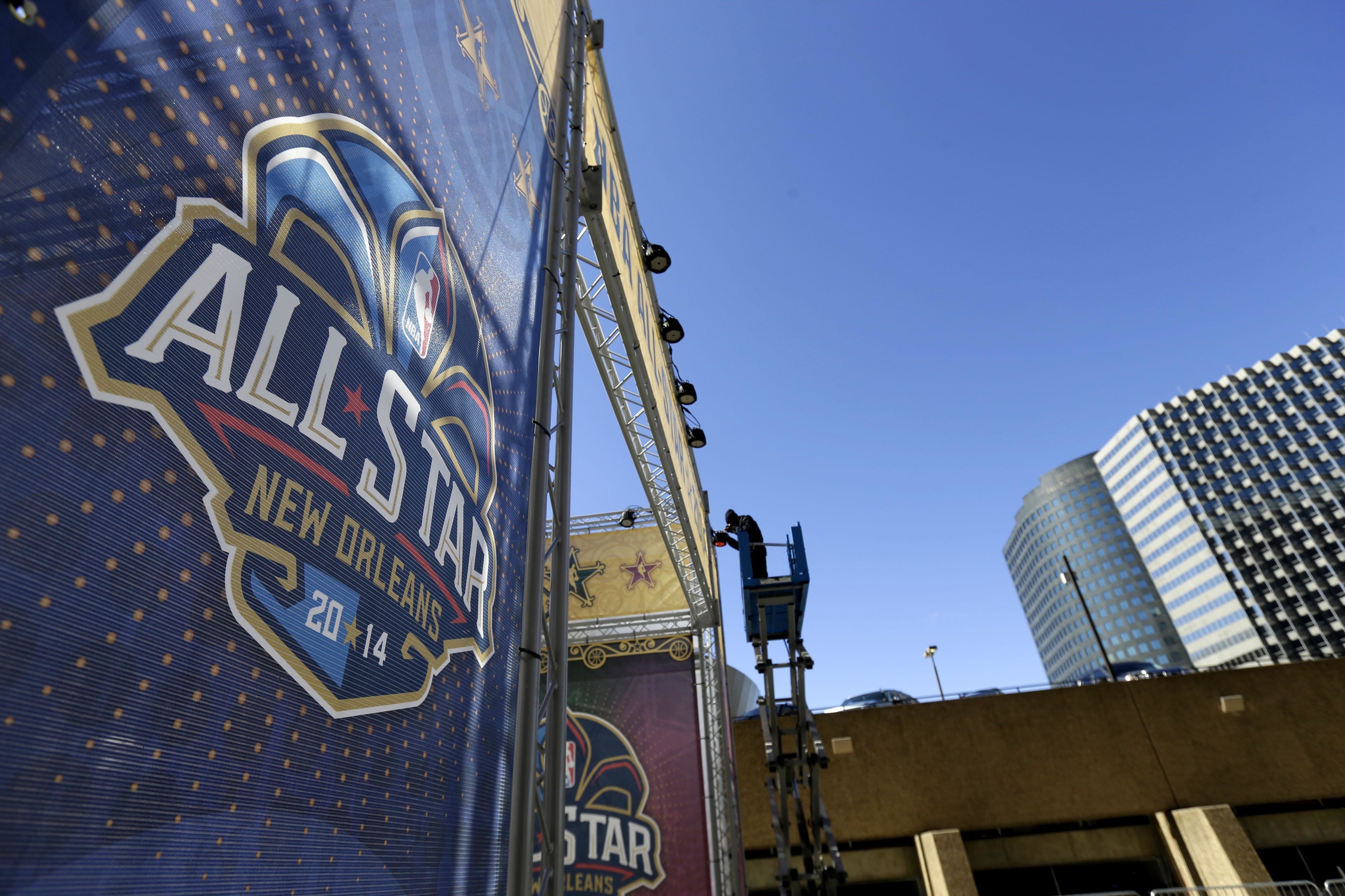 A worker attaches a banner to a scaffolding in New Orleans in preparation of the 2014 NBA All-Star basketball game. The NBA has decided to hold the 2017 All-Star Game in New Orleans, a person familiar with the decision told The Associated Press. The person spoke to the AP on condition of anonymity Friday, Aug. 19, 2016, because the decision hasn't been announced. New Orleans replaces Charlotte, which was set to host the game until the NBA decided last month that it wouldn't hold its marquee, mid-season event in North Carolina because of a state law that limits anti-discrimination protections for lesbian, gay and transgender people.