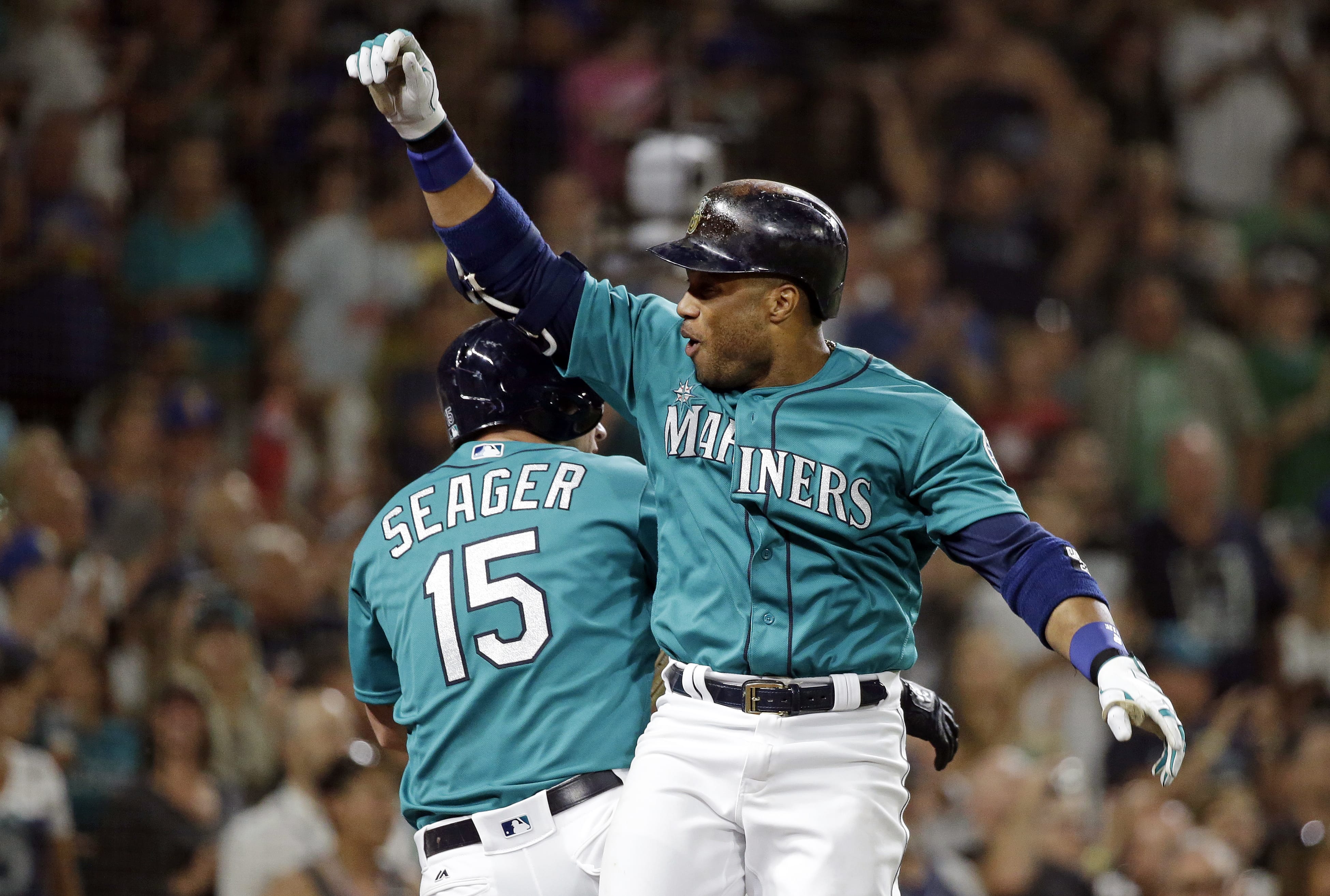 Seattle Mariners' Robinson Cano, right, celebrates with Kyle Seager after his two-run home run against the Milwaukee Brewers during the fifth inning of a baseball game Friday, Aug. 19, 2016, in Seattle.