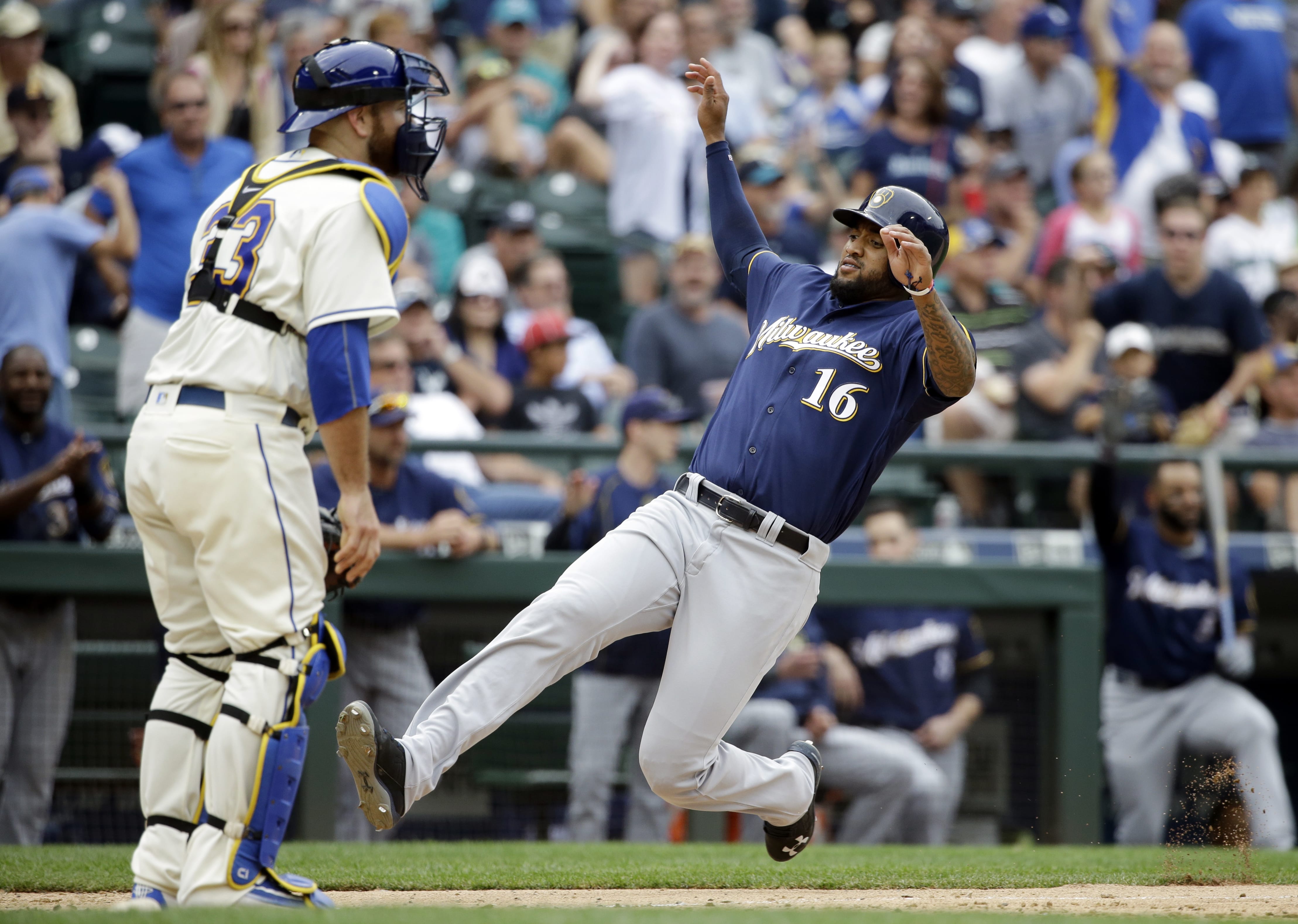 Seattle Mariners catcher Chris Iannetta waits for the throw as Milwaukee Brewers' Domingo Santana slides safely into home to score in the ninth inning of a baseball game, Sunday, Aug. 21, 2016, in Seattle.