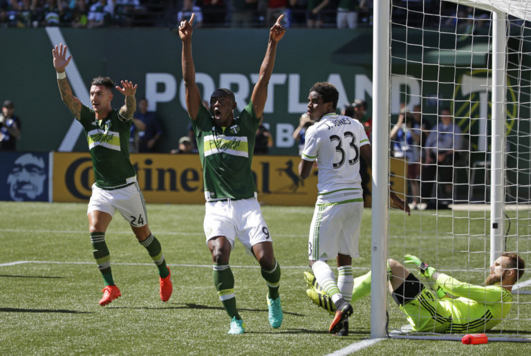 Portland Timbers' Liam Ridgewell, left, and Fanendo Adi, second from left, celebrate after Timbers' Vytas Andriuskevicius (not shown) scored a goal against Seattle Sounders goalkeeper Stefan Frei, right, in the first half of an MLS soccer match, Sunday, Aug. 28, 2016, in Portland, Ore. (AP Photo/Ted S.