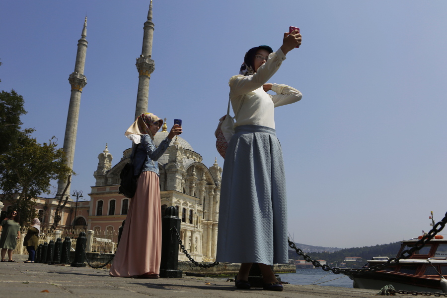 Women take photos outside the Ortakoy Mosque on Monday at the seaside of Istanbul. Turkey slammed a German court decision that prevented President Recep Tayyip Erdogan from addressing a demonstration in Germany denouncing Turkey&#039;s failed July 15 coup, and summoned a German diplomat in protest.