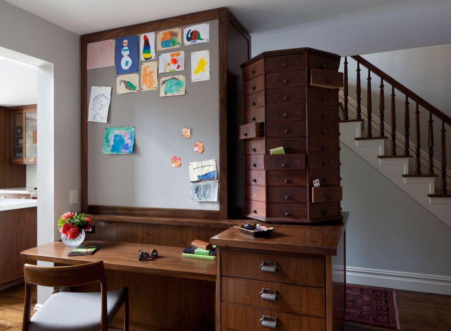 This homework space designed by Tamara Eaton features an oversized pinboard extending to the ceiling. The bulletin board is perfect for displaying kids&#039; latest works of art. An antique rotating cabinet, right, also provides useful storage with unique flair.
